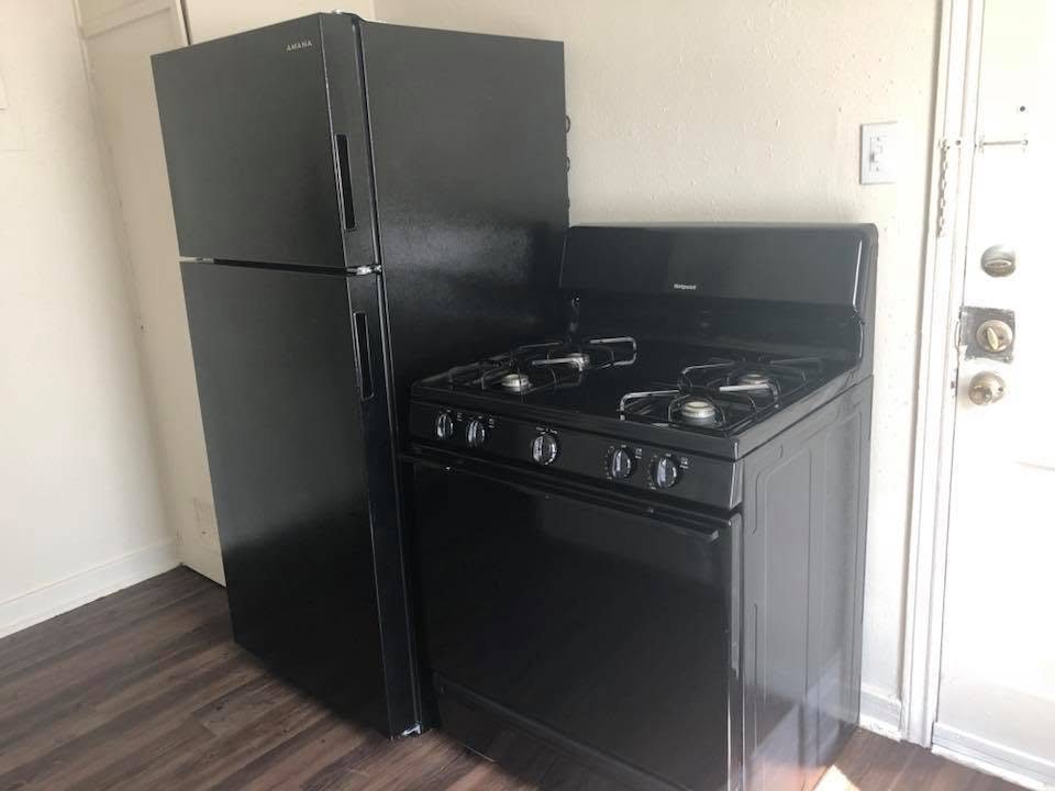 A turned unit with new black appliances and plank flooring