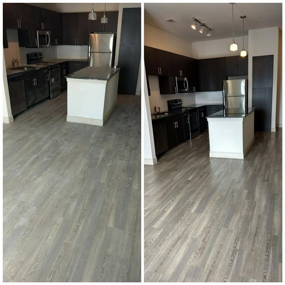 A turned apartment kitchen with dark cabinets and plank flooring